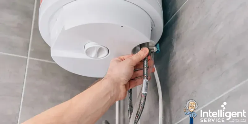 Hand checks pipes of a boiler in a bathroom, with Intelligent Service logo visible.