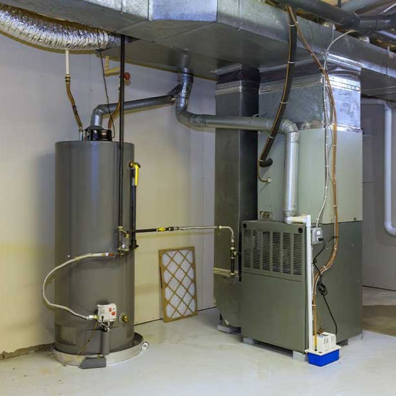 Basement HVAC system with a water heater and furnace, showcasing ductwork and ventilation pipes for home heating.